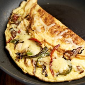 Chicken Fajita Omelette - in skillet with chicken, cheese, and peppers | The Worktop