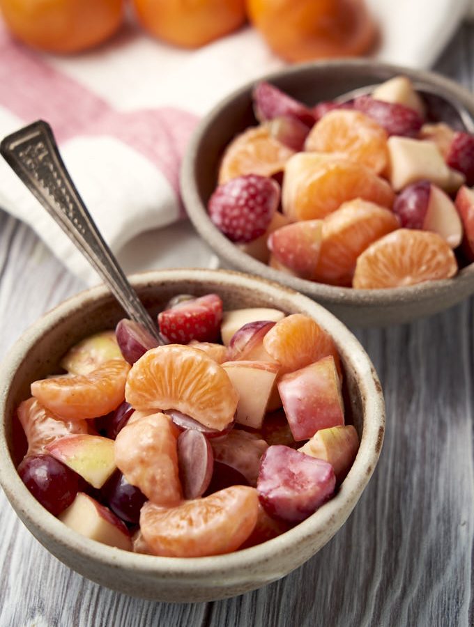 Fruit Salad with Yogurt - mandarins, apples, strawberries, grapes and yogurt dressing in a bowl | The Worktop