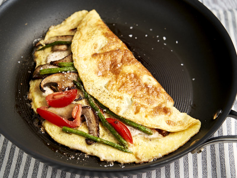Chicken Omelette Recipe - folded in half on skillet and showing asparagus, cheese and tomatoes | The Worktop